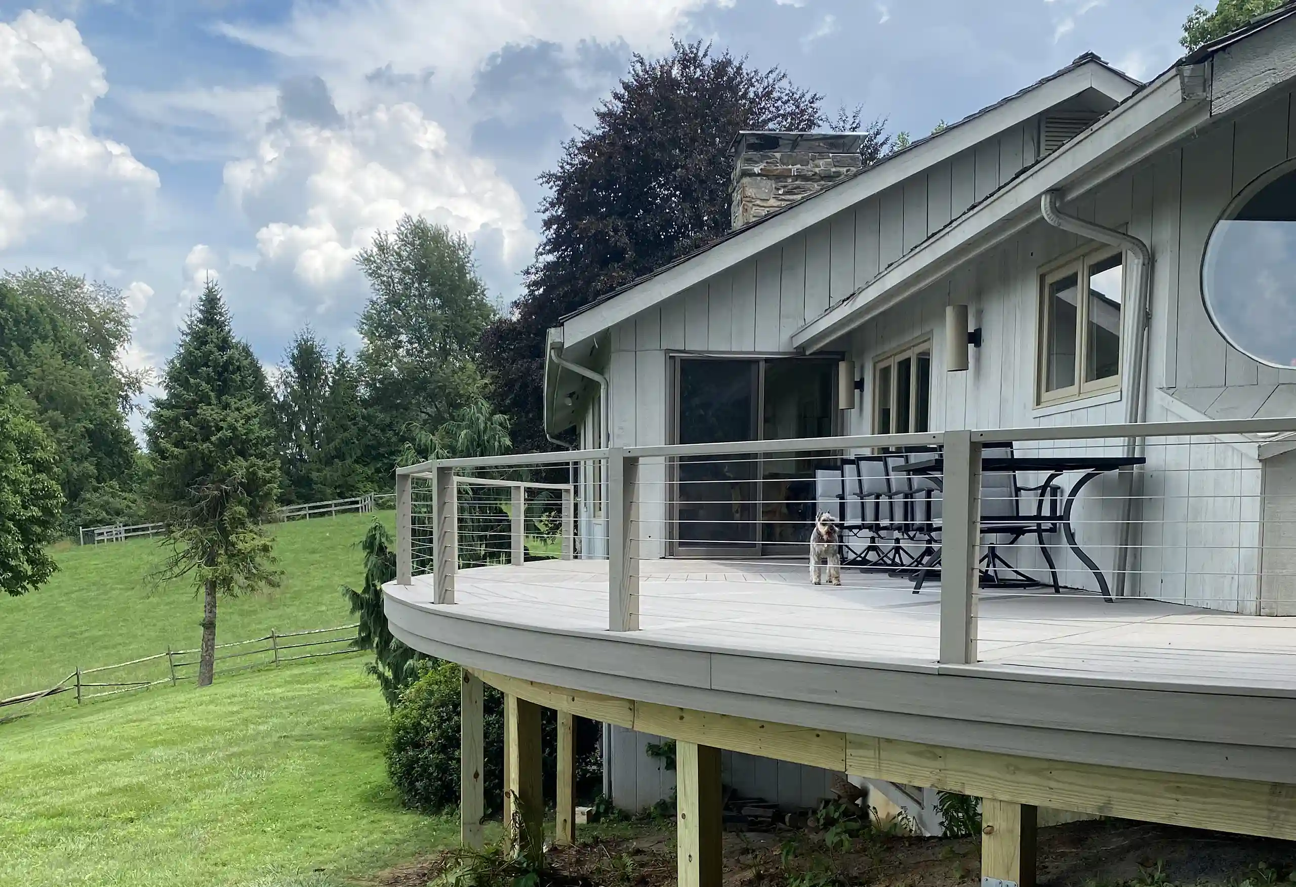 photo of a custom curved deck with cable railing - Composite Deck Builders and contractor in Avondale, PA