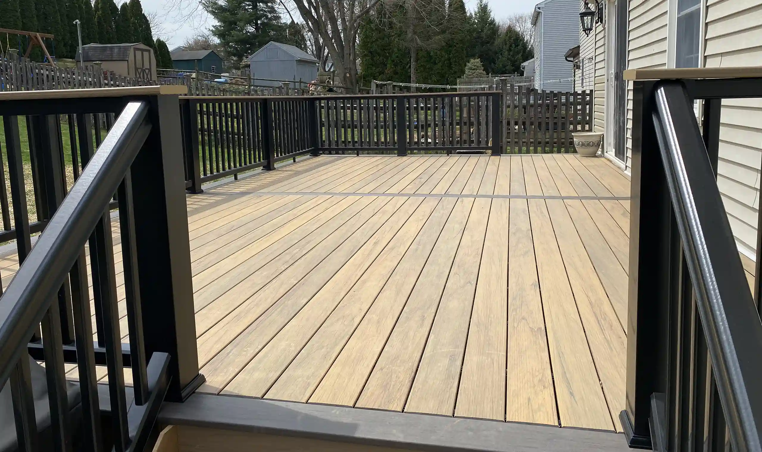 Photo of a custom deck with a composite decking material that looks like a natural wood deck - custom deck with a composite decking material - Deck Builders and contractors in Newark, DE