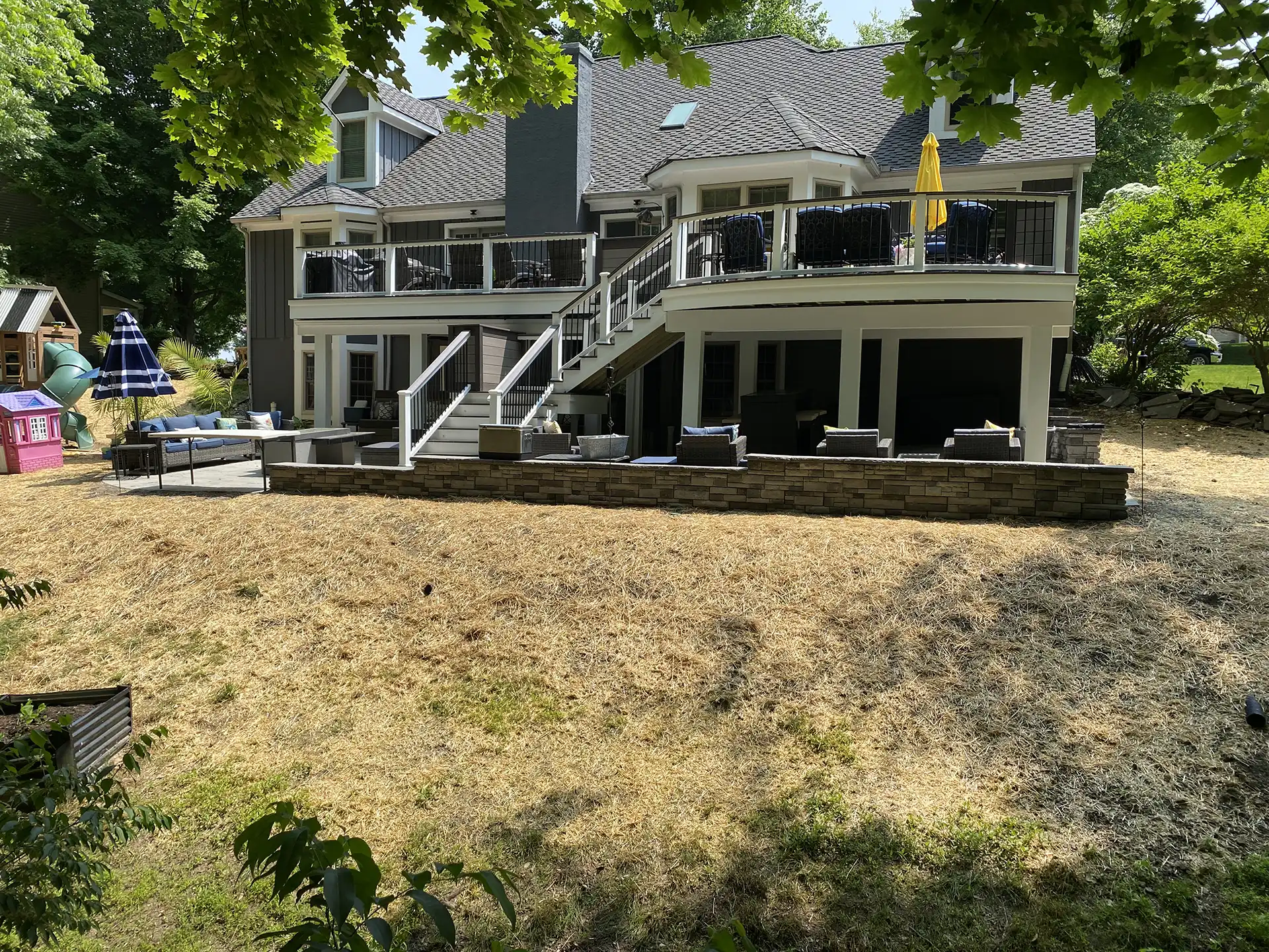 Photo of a custom deck with an elevated deck, steps, railing, and patio under deck